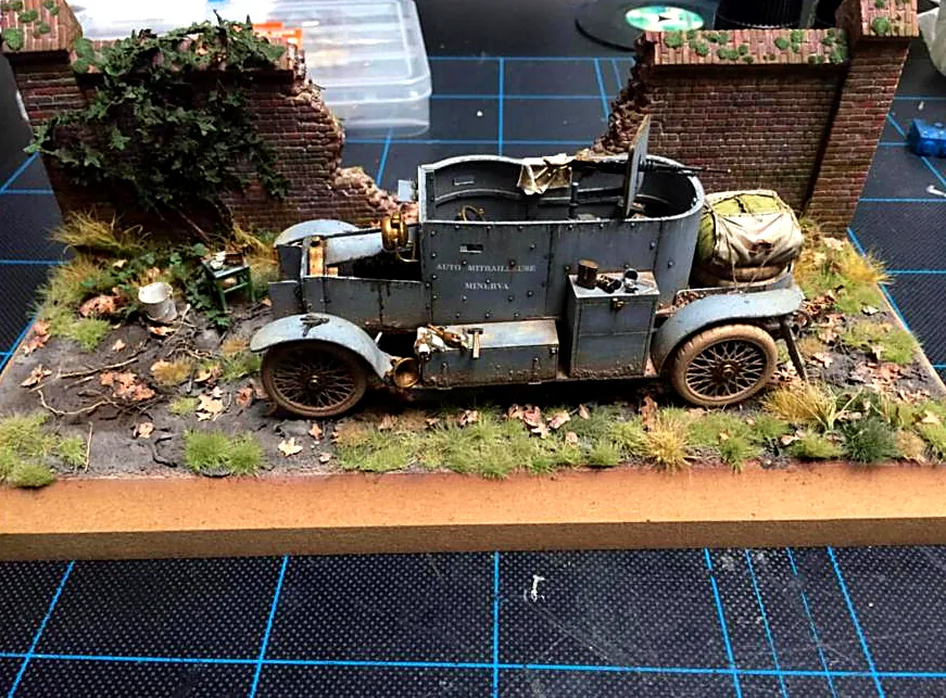 Diorama of an armoured car in front of a ruined brick wall