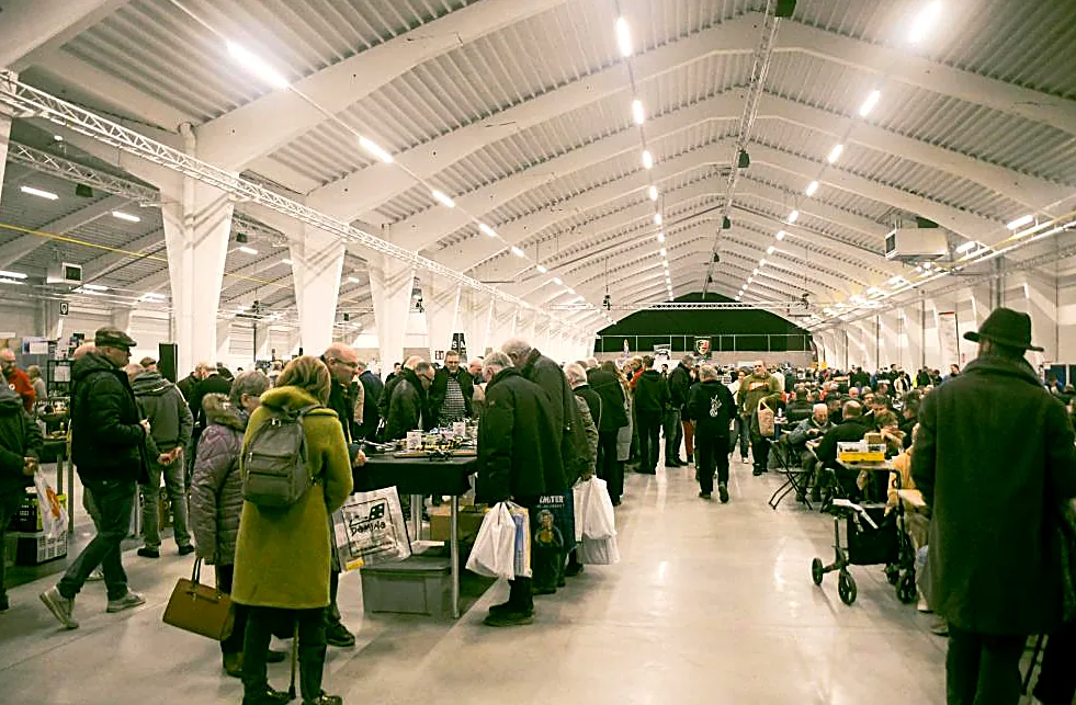 Visitors with shopping bags between the trader tables